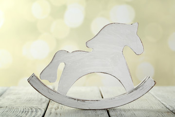 Wall Mural - Decorative rocking horse on wooden table, on light background