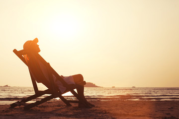 young woman enjoying sunset on the tropical beach