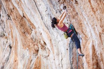 Wall Mural - Young female rock climber on overhanging cliff