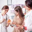 © DC Studio - Two doctors and one client inside pharmacy