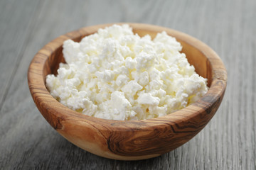 Wall Mural - fresh cottage cheese in a wood bowl on a wooden table