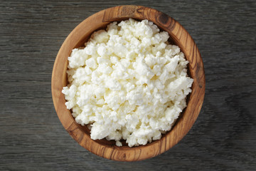 Sticker - fresh cottage cheese in a wood bowl on a wooden table