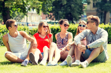 Canvas Print - group of smiling friends outdoors sitting on grass