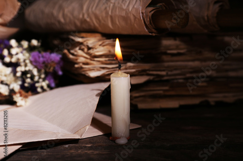 Fotografie, Tablou Still life with retro books and candlelight on wooden table, closeup