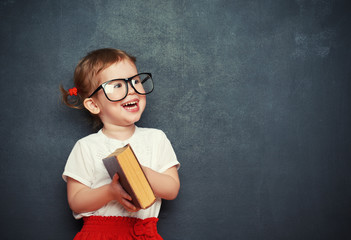 Wall Mural - happy  girl schoolgirl with book from blackboard