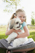 © Mike Kemp/Blend Images - Caucasian girl hugging dog in grass