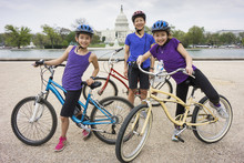 Mother And Daughters Riding Bicycles By Capitol Building, District Of Columbia, United States