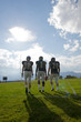 © Pete Saloutos/Blend Images - Football players walking on field