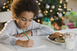 © JGI/Blend Images - Mixed Race boy writing letter to Santa Claus