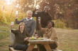 © John Fedele/Blend Images - Friends having picnic and drinking wine