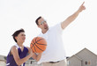 © Mike Kemp/Blend Images - Father teaching son to play basketball in driveway