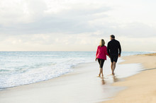 Caucasian Couple Walking On Beach