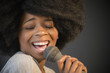 © JGI/Jamie Grill/Blend Images - Mixed race woman singing into microphone