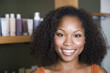© Tanya Constantine/Blend Images - African American woman in front of hair care products