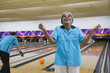 © Blend Images - African woman cheering in bowling alley