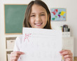 © JGI/Jamie Grill/Blend Images - Mixed race girl holding paper with A+ grade