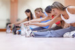 © Andres Rodriguez/Blend Images - Hispanic women stretching in gym