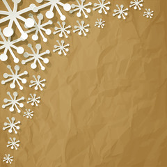 White paper snowflakes on crumpled paper brown background