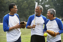 Senior Men With Baseball Gear Talking Outdoors