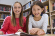 © Don Mason/Blend Images - Female students smiling in library