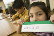 © Stretch Photography/Blend Images - Hispanic school girl displaying name card