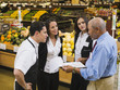 © Erik Isakson/Blend Images - Businessman and workers talking in grocery store