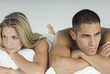 © Gabriela Medina/Blend Images - Angry Hispanic couple laying in bed
