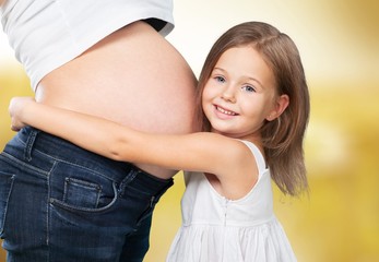 Wall Mural - Pregnant. Beautiful pregnant woman with her daughter. Isolated