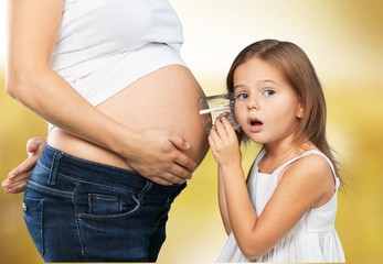 Wall Mural - Pregnant. Kid girl listening with can pregnant mother's stomach