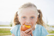 © Mike Kemp/Blend Images - Caucasian girl eating fruit outdoors