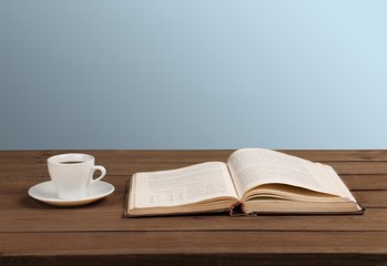 Sticker - Book. Cup of coffee and a book on a wooden table