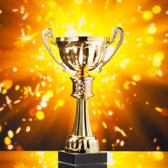 Wall Mural - gold cup trophy against shiny sparks background