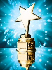 Wall Mural - gold star trophy against blue sparks background