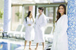 © NDABCREATIVITY - Friends relaxing in a spa next to a swimming pool