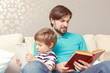 © zinkevych - Father and son read a book or tablet