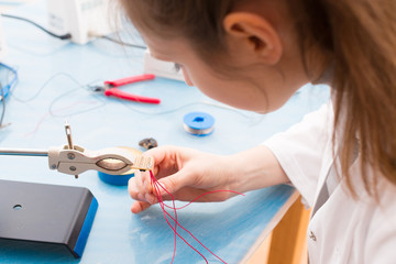 Wall Mural - Young woman assemble optic sensor for intelligent robot system