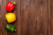 Colorful bell peppers on wooden table