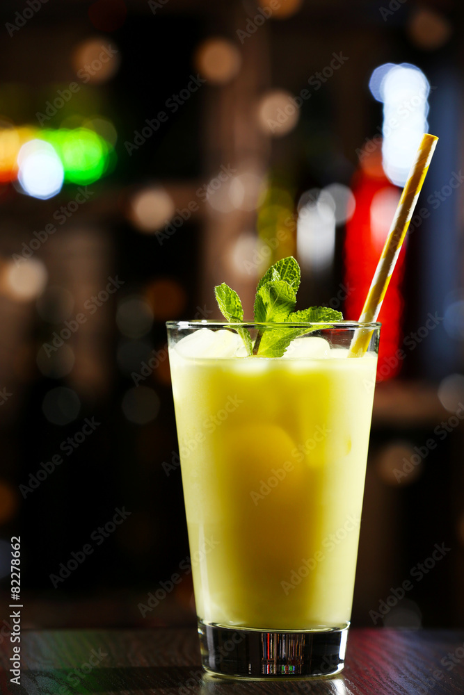 Glass of cocktail in bar on bright blurred background