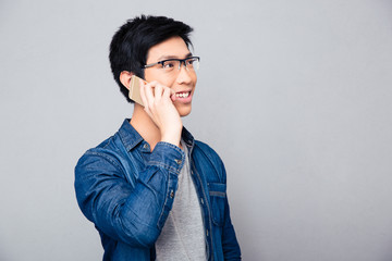 Poster - Smiling asian man talking on the phone