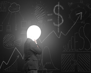 Thinking businessman with lamp head illuminated dark business do