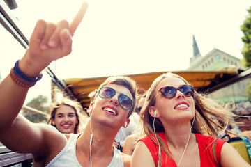 smiling couple with earphones traveling by bus