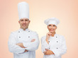 © Syda Productions - happy chefs or cooks couple over beige background