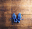 © Halfpoint - Pair of blue running shoes laid on a wooden floor background
