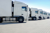 LKW-Spedition, mehrere weiße Laster stehen nebeneinander