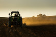 Tractor in sunset plowing the field