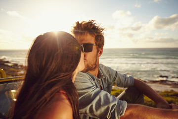 Wall Mural - Affectionate young couple kissing at the beach