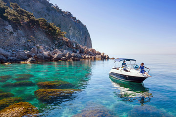 Wall Mural - Woman relaxing on boat in sea near shore. Traveling near island