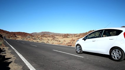 Sticker - Car drives by on empty raod in desert mountain landscape