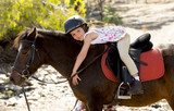 happy child girl with pony horse as young jockey in Summer
