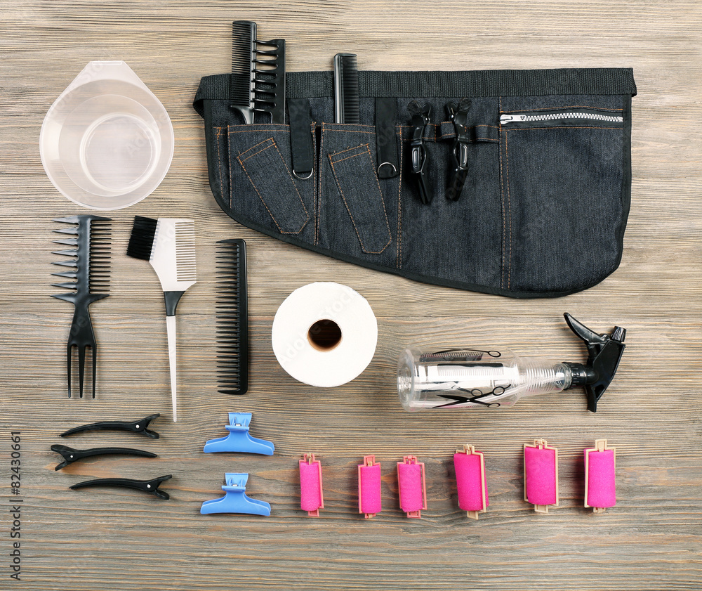 Hairdressing tools on wooden background